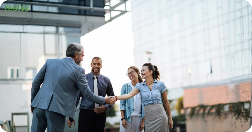 Business representatives shaking hands outside an office, representing the commitment and trust offered by Indonesian VCO suppliers.