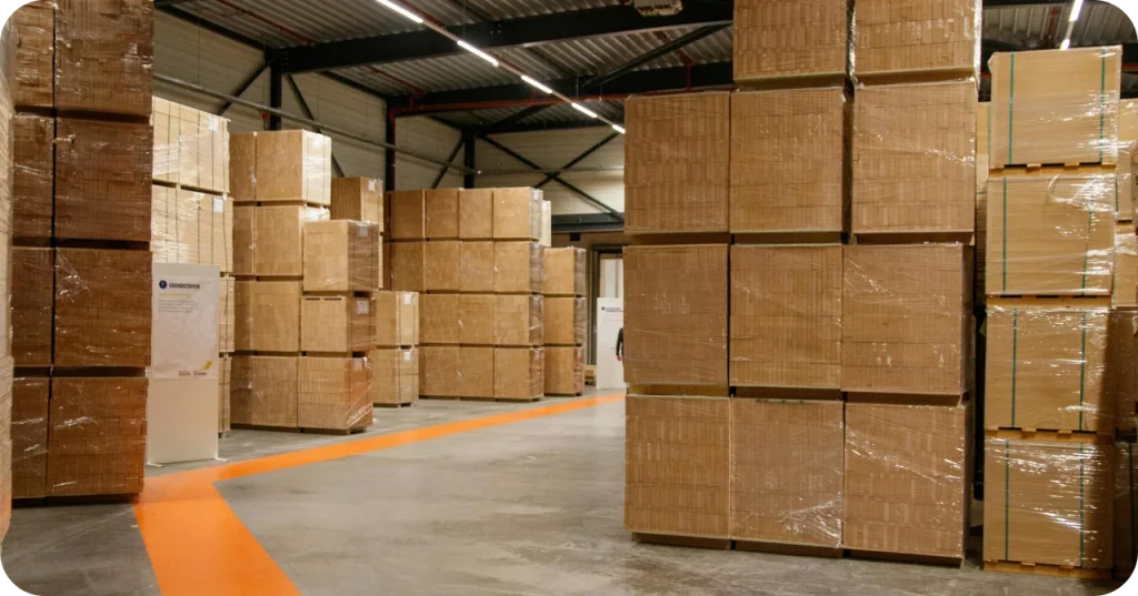 Industrial warehouse interior showing organized rows of shrink-wrapped pallets, illustrating the stock readiness for bulk coconut sugar exports.